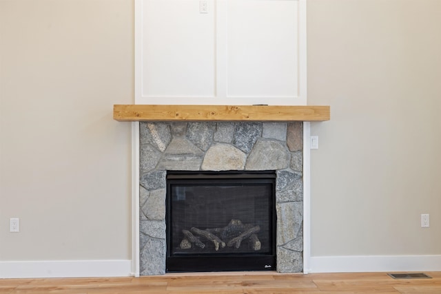 276 Sterling Dr, Laconia, NH 03246 - detailed view of baseboards, a stone fireplace, and wood finished floors