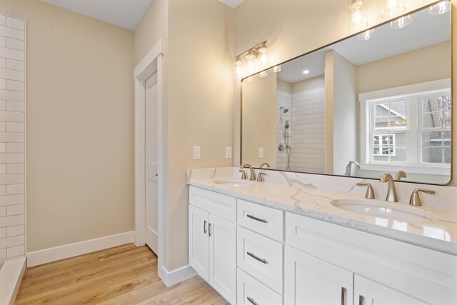 276 Sterling Dr, Laconia, NH 03246 - full bathroom featuring a tile shower, wood finished floors, baseboards, and double vanity