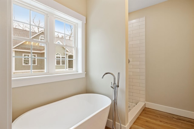 276 Sterling Dr, Laconia, NH 03246 - bathroom with a soaking tub, a shower stall, wood finished floors, and baseboards