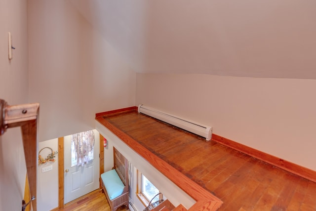 interior space featuring lofted ceiling, wood finished floors, and a baseboard radiator