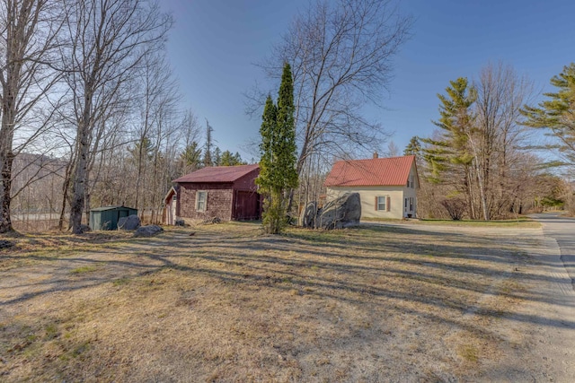 view of home's exterior with an outdoor structure, a yard, and a shed