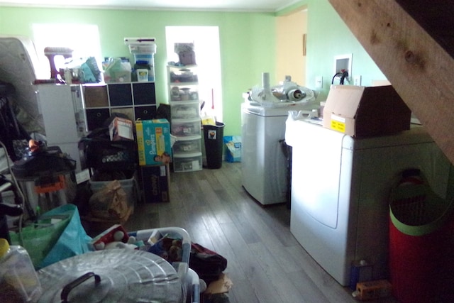washroom with light wood-type flooring and washing machine and dryer