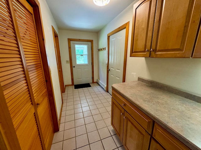 doorway with baseboard heating and light tile patterned floors