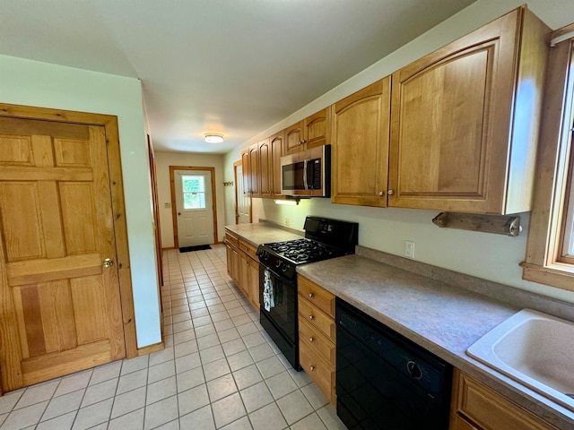 kitchen with black appliances, light tile patterned floors, and sink