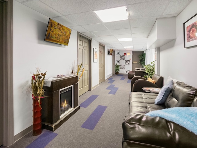 carpeted living room featuring a paneled ceiling