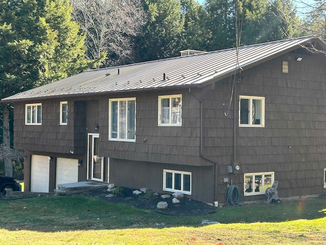 back of house featuring a garage and a yard