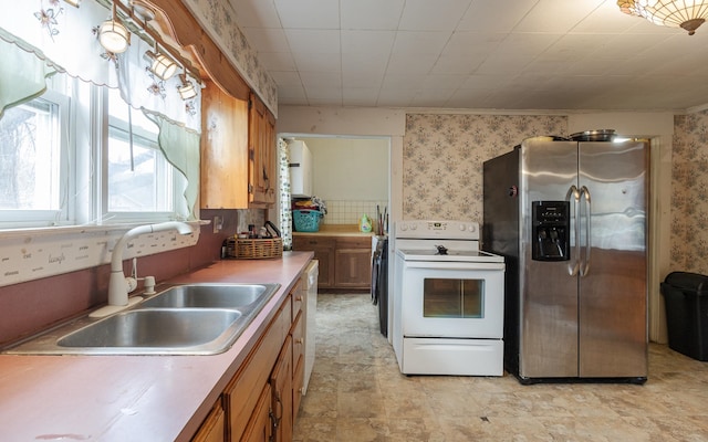 kitchen with stainless steel refrigerator with ice dispenser, sink, and electric range