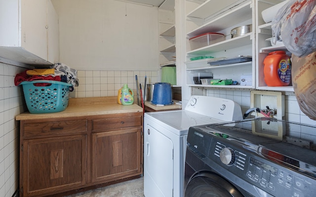 laundry room with tile walls and washer and clothes dryer