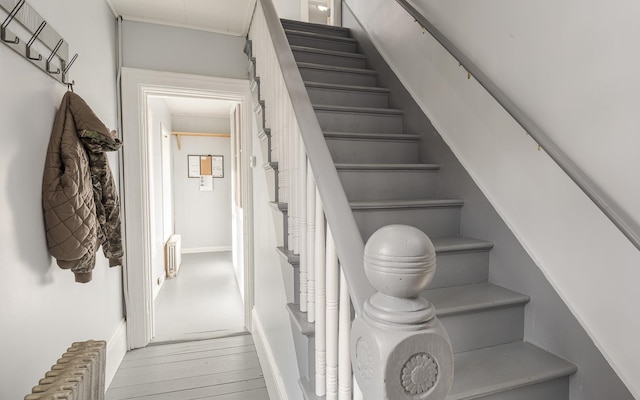 stairway with radiator and hardwood / wood-style floors