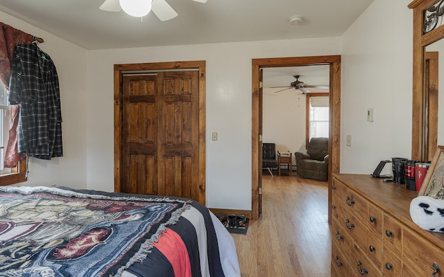 bedroom with ceiling fan, a closet, and light hardwood / wood-style flooring