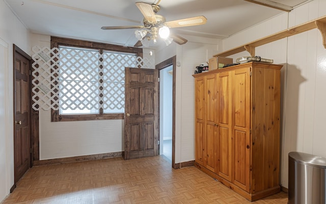 unfurnished room featuring ceiling fan, wooden walls, and light parquet floors