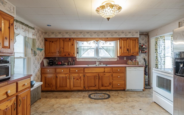 kitchen with white appliances, sink, and a wealth of natural light