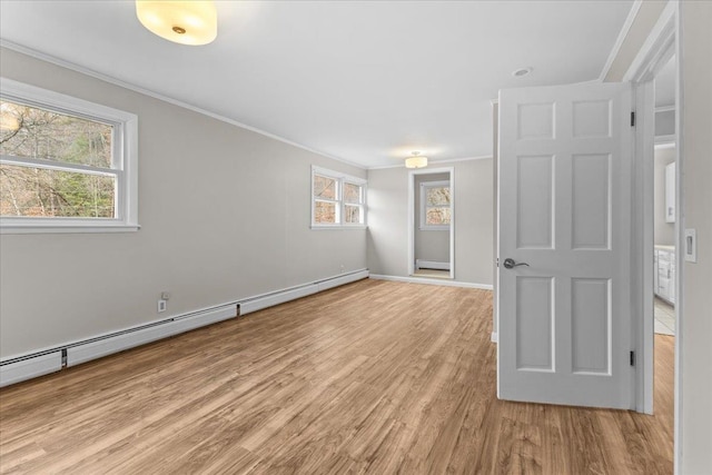 unfurnished room with ornamental molding, a baseboard radiator, and light wood-type flooring