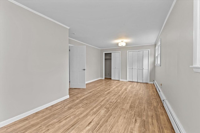 unfurnished bedroom featuring multiple closets, crown molding, and light wood-type flooring