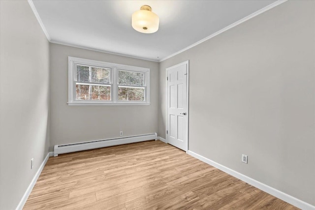 empty room featuring crown molding, light hardwood / wood-style floors, and a baseboard heating unit