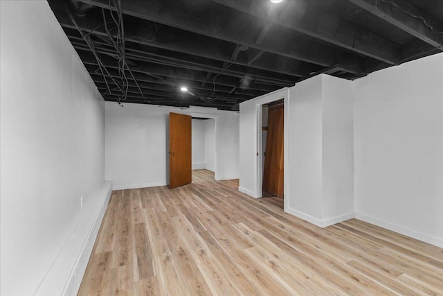 basement with light hardwood / wood-style flooring