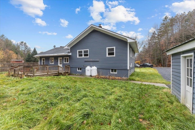 rear view of house featuring a lawn and a wooden deck