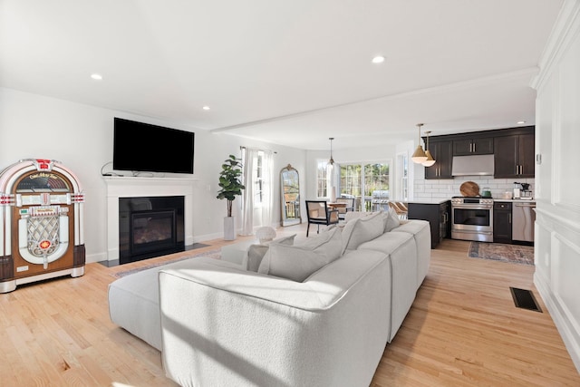 living room with light hardwood / wood-style floors and ornamental molding