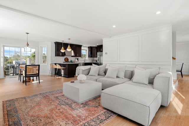 living room featuring crown molding and light wood-type flooring