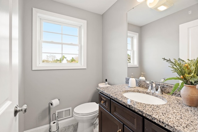 bathroom with vanity, a healthy amount of sunlight, and toilet