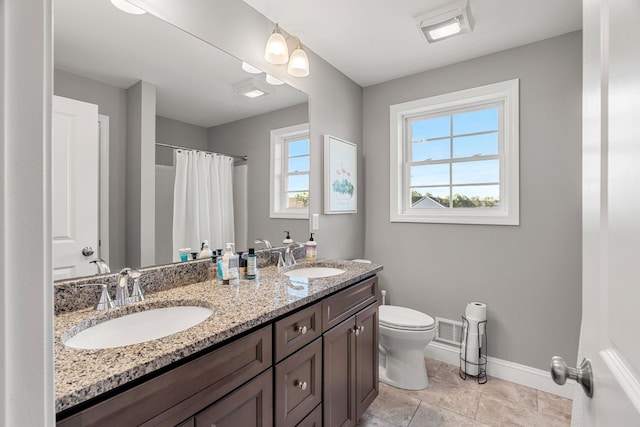 bathroom featuring curtained shower, tile patterned flooring, vanity, and toilet