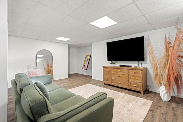 living room featuring wood-type flooring and a paneled ceiling