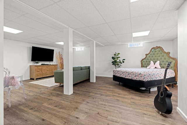 bedroom featuring wood-type flooring and a paneled ceiling