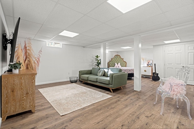 living room featuring hardwood / wood-style flooring and a drop ceiling