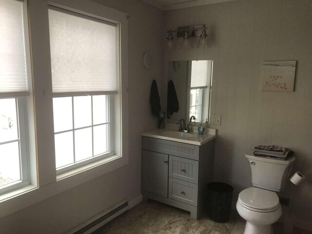 bathroom featuring baseboard heating, a wealth of natural light, and vanity