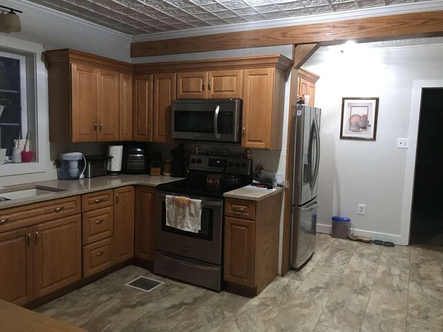 kitchen with sink, ornamental molding, and stainless steel appliances