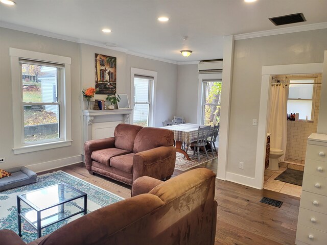 living room with a wealth of natural light, crown molding, and hardwood / wood-style flooring