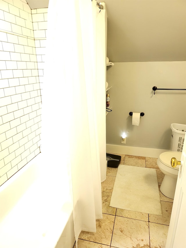 bathroom with tile patterned floors, tiled shower / bath, and toilet