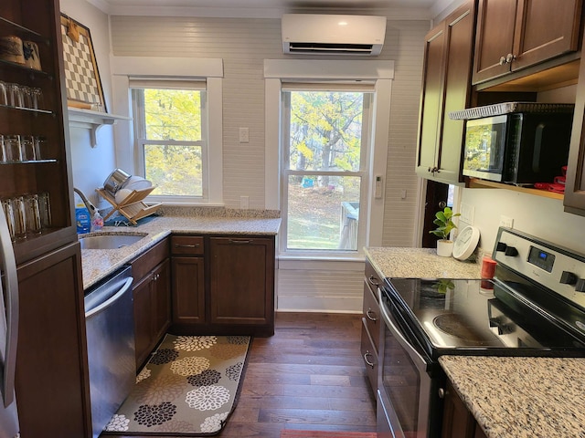 kitchen with a wall mounted AC, a wealth of natural light, dark hardwood / wood-style flooring, and appliances with stainless steel finishes