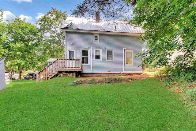 rear view of house featuring a lawn and a wooden deck