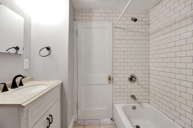 bathroom with tile patterned floors, a textured ceiling, vanity, and tiled shower / bath combo