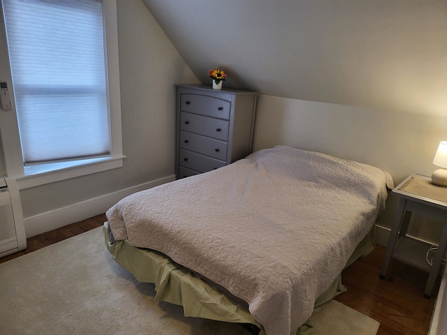 bedroom featuring dark hardwood / wood-style flooring and lofted ceiling