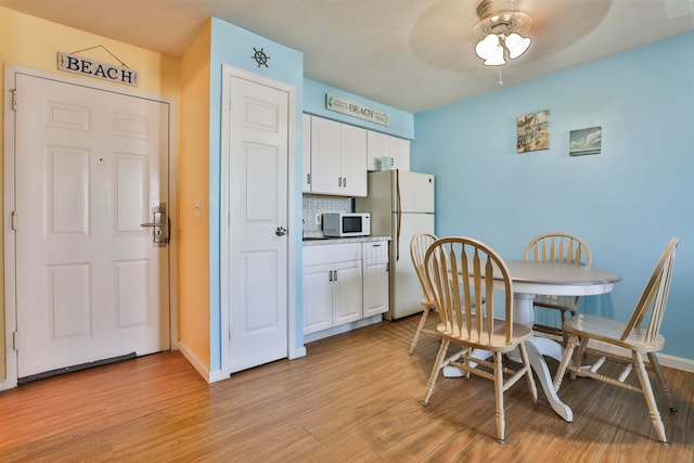 dining area with ceiling fan and light hardwood / wood-style flooring