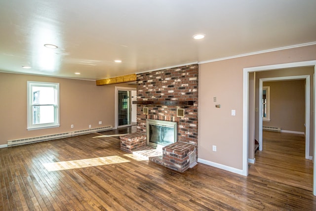 unfurnished living room with a fireplace, hardwood / wood-style floors, baseboard heating, and ornamental molding