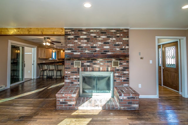 unfurnished living room featuring a brick fireplace, ceiling fan, hardwood / wood-style floors, and ornamental molding