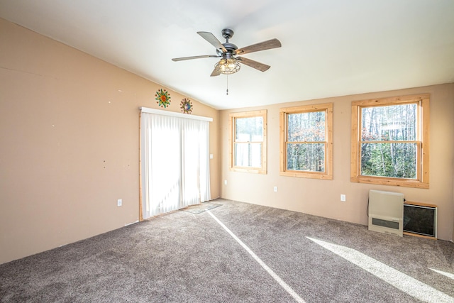 unfurnished bedroom with heating unit, ceiling fan, carpet floors, and vaulted ceiling