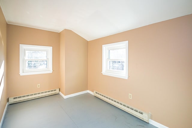 unfurnished room featuring plenty of natural light and a baseboard heating unit
