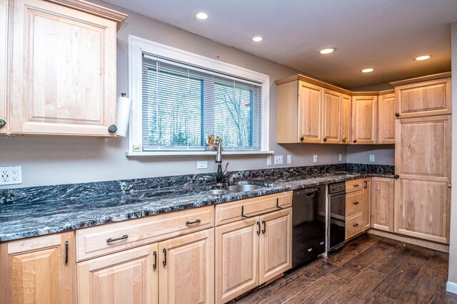 kitchen with sink, dark stone countertops, black dishwasher, light brown cabinetry, and dark hardwood / wood-style flooring