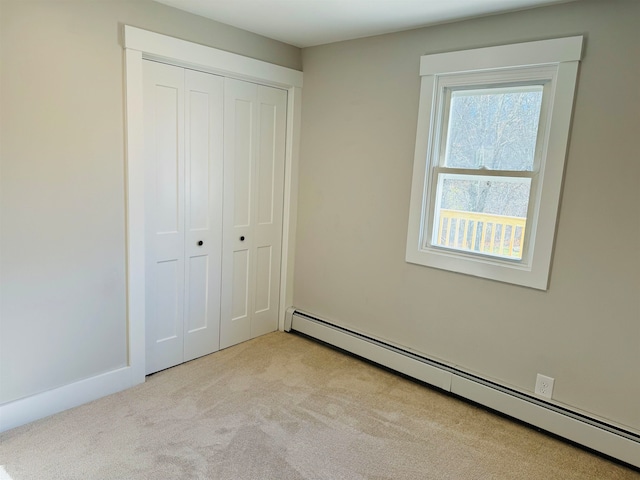 unfurnished bedroom with a closet, light carpet, and a baseboard radiator