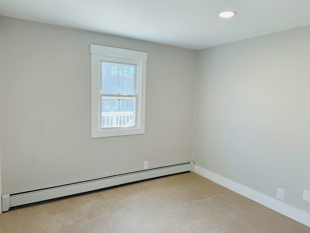 carpeted spare room featuring baseboard heating