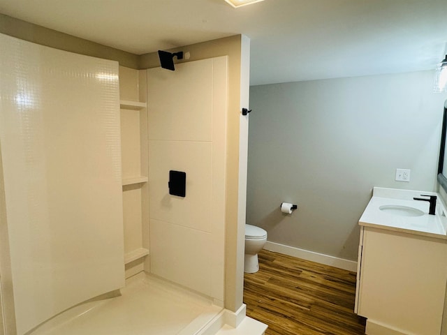 bathroom with walk in shower, toilet, vanity, and hardwood / wood-style flooring