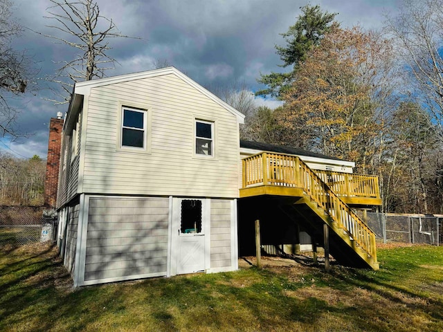 rear view of property with a lawn and a wooden deck