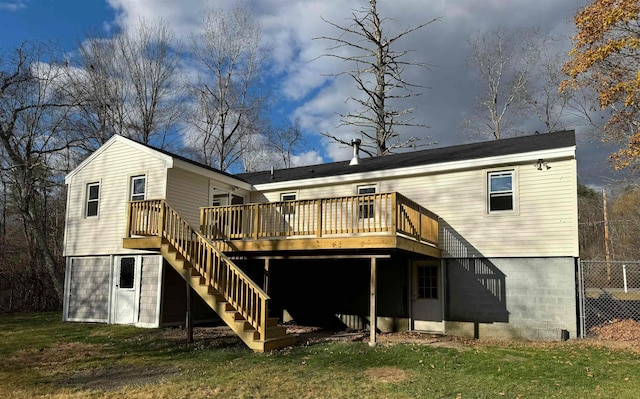 rear view of property featuring a yard and a wooden deck