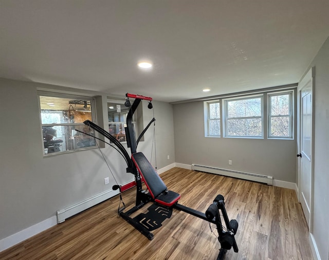 workout area featuring hardwood / wood-style flooring, plenty of natural light, and a baseboard radiator