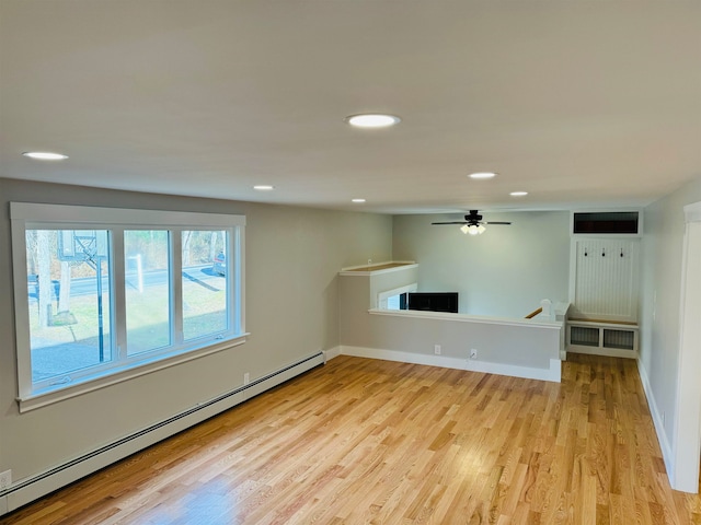 unfurnished living room featuring light wood-type flooring, baseboard heating, and ceiling fan