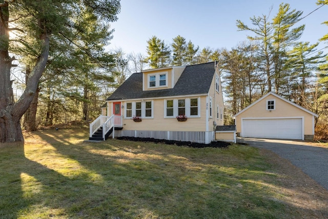 view of front of property featuring a garage, an outbuilding, and a front yard